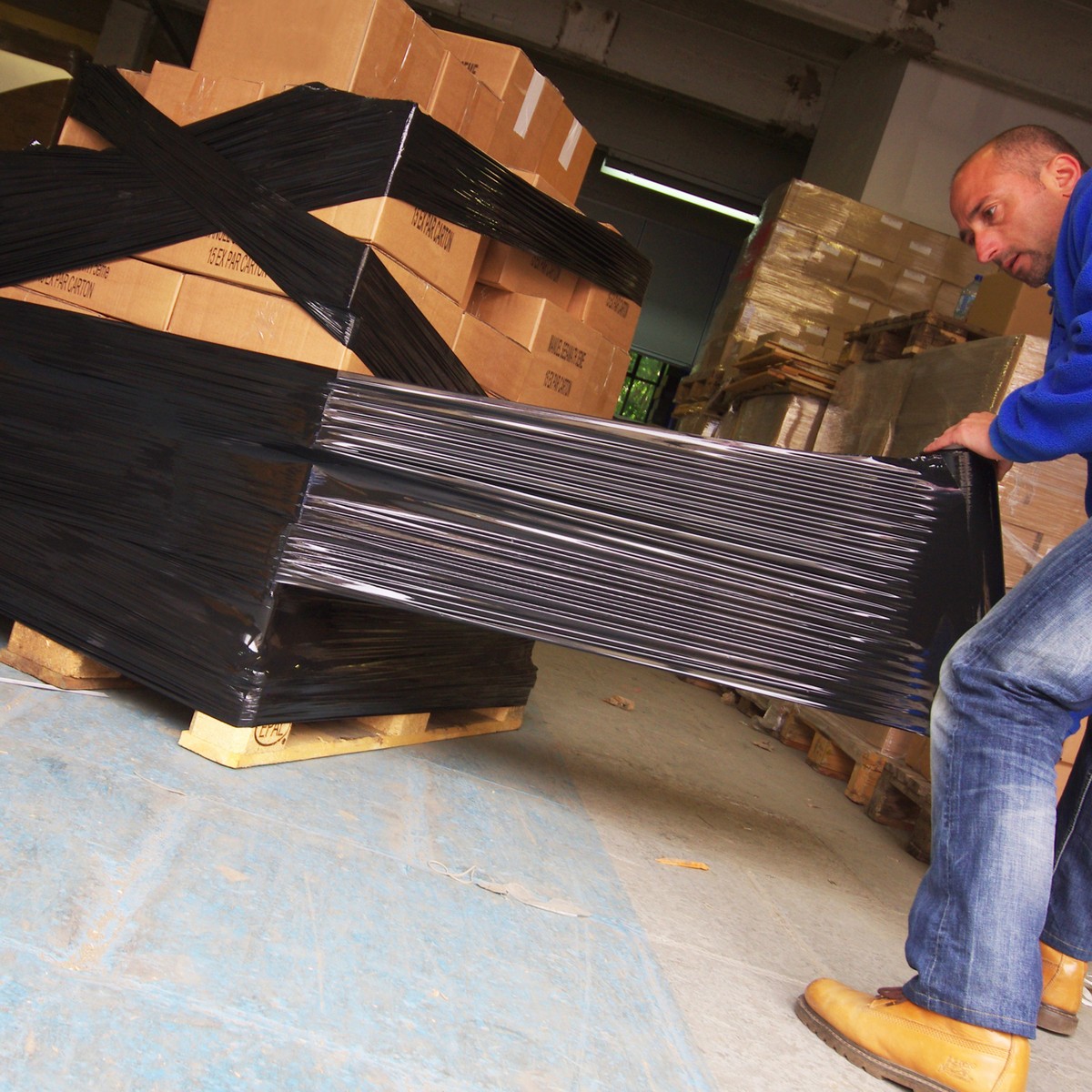 A pallet being wrapped in black stretch film